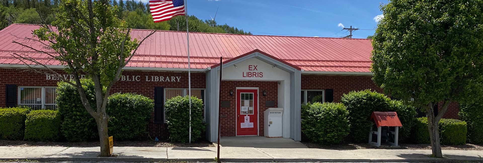 Beaverdale library has a red roof, door, and black shutters.