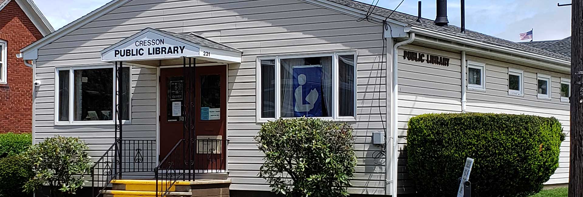 Beaverdale library has a red roof, door, and black shutters.